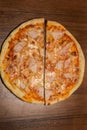 top vertical view on two halfs of pizza with ham and pineapple