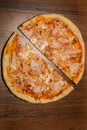 top vertical view on two halfs of pizza with prosciutto and pineapple