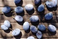 Top vie of juicy damsons plums on the wooden table as a background. Delicious sweet seasonal fruits Royalty Free Stock Photo