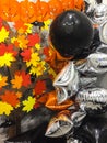 Top viev yellow ghosts pumpkins with colorful autumn leaves , silver and black toys, halloween concept