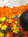 Top viev yellow ghosts pumpkins with colorful autumn leaves , silver and black toys, halloween concept