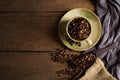 Top view above of Black coffee beans in brown ceramic cup with coffee beans roasted in burlap sack bag on wooden table background Royalty Free Stock Photo