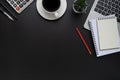 Top view above of black office desk table with keyboard of laptop, notebook and coffee cup with equipment office supplies. Royalty Free Stock Photo