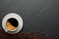 Top view, above from of Hot fresh black coffee with milk foam for morning menu in white ceramic cup with coffee beans roasted on d Royalty Free Stock Photo