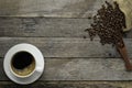 Top view above of Hot fresh black coffee with milk foam in a white ceramic cup with coffee beans roasted in sack bag on wood rusti Royalty Free Stock Photo