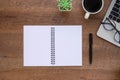 Top view above of Opened Blank notebook on wood office desk table with keyboard of laptop and equipment other office supplies. Royalty Free Stock Photo