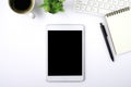 Top view above of tablet blank monitor black screen on white office desk table with notebook Royalty Free Stock Photo