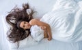 Top view from above to an attractive, young, sexy, wild, windblown, brunette, portrait of woman in bed hugging the bedspread, copy Royalty Free Stock Photo