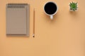 Two brown spiral school notebook and pencil with coffee cup isolated on brown background