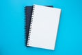 Top view above of two spiral notebooks that open and close, stacked isolated on light blue background for design a mockup.