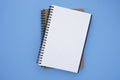 Top view above of two spiral notebooks that open and close, stacked isolated on light blue background for design a mockup.