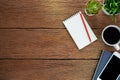 Top view above of Wood office desk table with Blank open notebook, pen and phone with equipment other office supplies. Business an Royalty Free Stock Photo