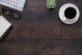 Top view above of Wooden office desk table with keyboard, notebook and coffee cup with equipment other office supplies. Business a Royalty Free Stock Photo