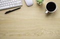 Top view above of Wooden office desk table with keyboard, notebook and coffee cup with equipment other office supplies. Royalty Free Stock Photo