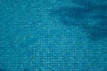 Top view of abstract blurred texture of blue wave water with mosaic tiles in swimming pool. Royalty Free Stock Photo