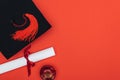 Top view of academic cap, diploma and apple on red surface. Royalty Free Stock Photo