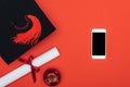 Top view of academic cap, diploma, apple and smartphone with blank screen on red surface. Royalty Free Stock Photo