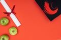 Top view of academic cap, diploma and apples on red surface. Royalty Free Stock Photo