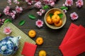Top view accessories Chinese new year festival decorations.orange,leaf,wood basket,red packet,plum blossom,teapot on wooden table Royalty Free Stock Photo