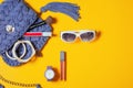 Top view accessories for woman. Stylish sunglasses, blue trendy knitted hand made bag, violet watch , lipstick, bracelet and brush Royalty Free Stock Photo