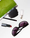 Top view accessories for woman. Stylish sunglasses, green bag , lipstick , perfume , fashion flat lay on white Royalty Free Stock Photo