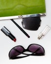 Top view accessories for woman. Stylish sunglasses, green bag , lipstick , perfume , fashion flat lay on white Royalty Free Stock Photo