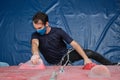 Top view of an active sporty man wearing protective face mask practicing rock climbing on artificial rock in a climbing wall Royalty Free Stock Photo