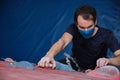 Top view of an active sporty man wearing protective face mask practicing rock climbing on artificial rock in a climbing wall Royalty Free Stock Photo