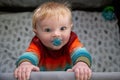 Top view of adorable baby boy standing looking up from his playpen Royalty Free Stock Photo