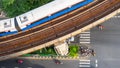 Top view aerial of a driving car on asphalt track and pedestrian crosswalk in traffic road  with sky train run on the top rail Royalty Free Stock Photo