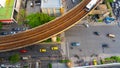 Top view aerial of a driving car on asphalt track and pedestrian crosswalk in traffic road  with sky train run on the top rail Royalty Free Stock Photo