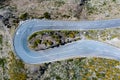 Top view aerial drone image of asphalt road 180 degrees curve surrounded by cliffs on Madeira island, Portugal. Safety transport