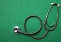 Image of a top view stethoscope on a green background, concept of health and medicine.