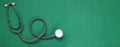 Image of a top view stethoscope on a green background, concept of health and medicine.