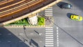 Top view aerial photo of a driving car on asphalt track and pedestrian crosswalk in traffic road with light and shadow silhouette