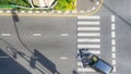 Top view aerial photo of a driving car on asphalt track and pedestrian crosswalk in traffic road with light and shadow silhouette Royalty Free Stock Photo