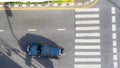 Top view aerial photo of a driving car on asphalt track and pedestrian crosswalk in traffic road with light and shadow silhouette Royalty Free Stock Photo