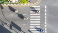 Top view aerial photo of a driving motorcycle on asphalt track and pedestrian crosswalk in traffic road with light and shadow