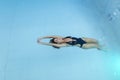 Top view aerial photo from flying drone of a seductive sexy model in white swimwear is enjoying relax in hotel pool during her Royalty Free Stock Photo