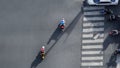 Top view aerial photo of motorcycle driving pass pedestrian crosswalk in traffic road with light and shadow silhouette
