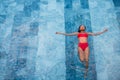 Top view aerial photo of a seductive model in white swimwear is enjoying relax in hotel pool during her summer Royalty Free Stock Photo