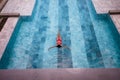 Top view aerial photo of a seductive model in white swimwear is enjoying relax in hotel pool during her summer Royalty Free Stock Photo