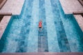 Top view aerial photo of a seductive model in white swimwear is enjoying relax in hotel pool during her summer Royalty Free Stock Photo