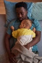 Top view African American father with baby son sleeping together at naptime