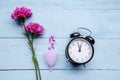 Alarm clock with roses, pills and sanitary cup Royalty Free Stock Photo