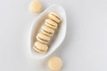 Top view of Alfajores,shortbread cookies filled with caramel and rolled in coconut. Argentinian macaroons on white plate