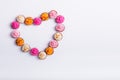 Top view Allsorts chocolate Sweets with multicolored cream filling arranged in heart shape on white background isolated. Happy