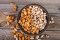 Top view of almonds and pistachios on a wooden bowl