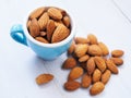 Almonds seeds in blue cup isolated in white table Royalty Free Stock Photo