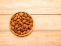 Top view almonds in wood plate on pine wood table with copy space